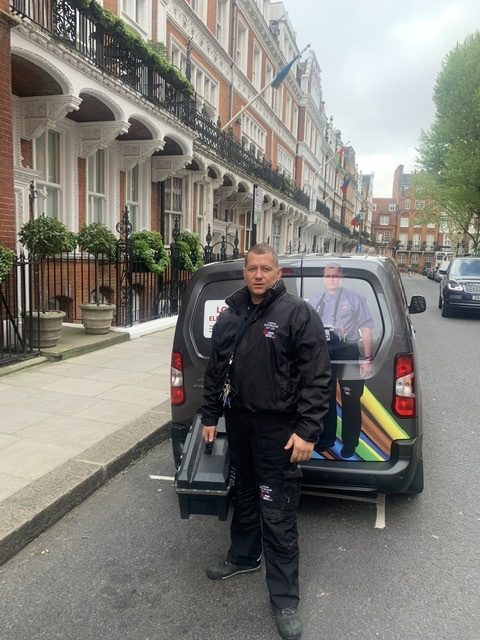 London Electrician stands in front of van